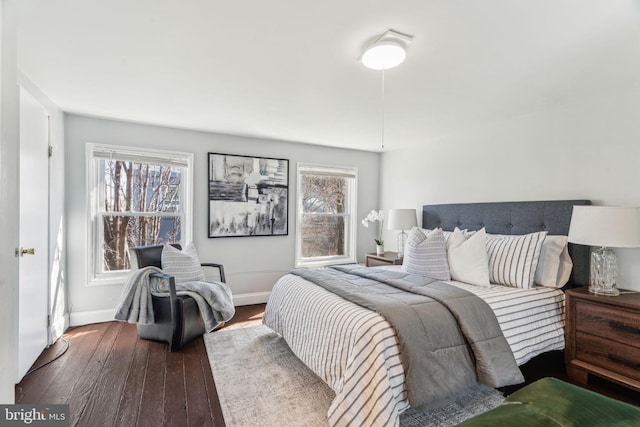 bedroom with baseboards and dark wood finished floors