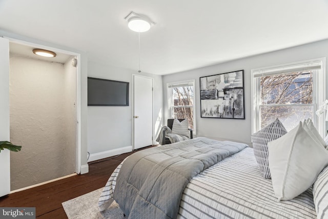 bedroom featuring baseboards and wood finished floors