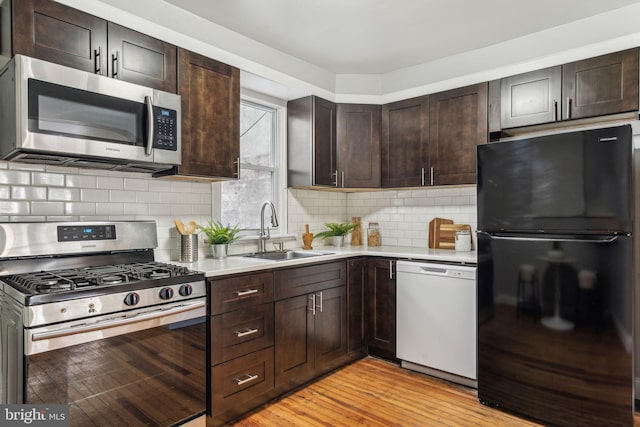 kitchen featuring dark brown cabinetry, stainless steel appliances, light countertops, and a sink