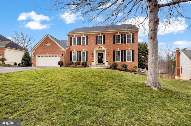 colonial home featuring an attached garage, brick siding, fence, driveway, and a front lawn