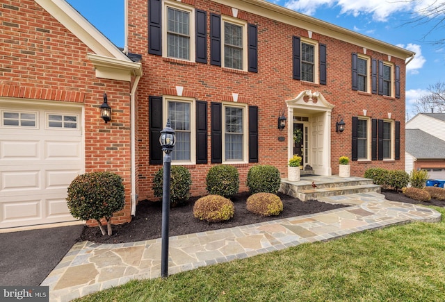 view of front facade with a garage and brick siding