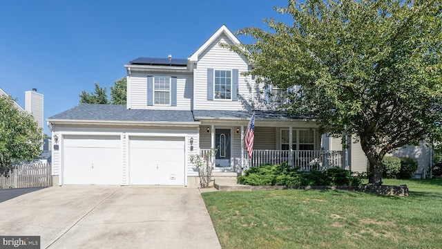 traditional-style home featuring a garage, concrete driveway, a porch, roof mounted solar panels, and a front lawn