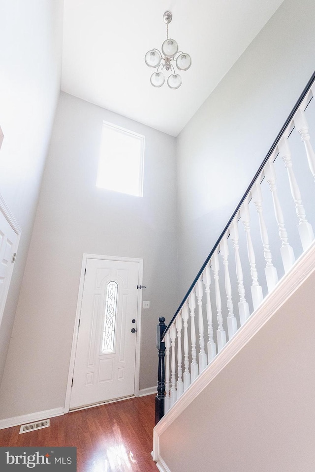 entrance foyer featuring wood finished floors, visible vents, plenty of natural light, and stairs