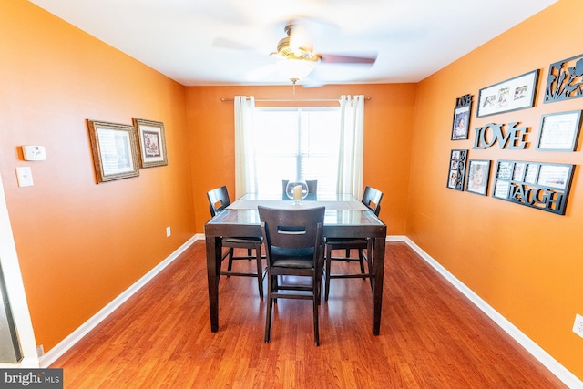 dining space with ceiling fan, wood finished floors, and baseboards