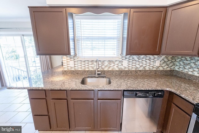 kitchen featuring light stone counters, crown molding, backsplash, stainless steel dishwasher, and a sink