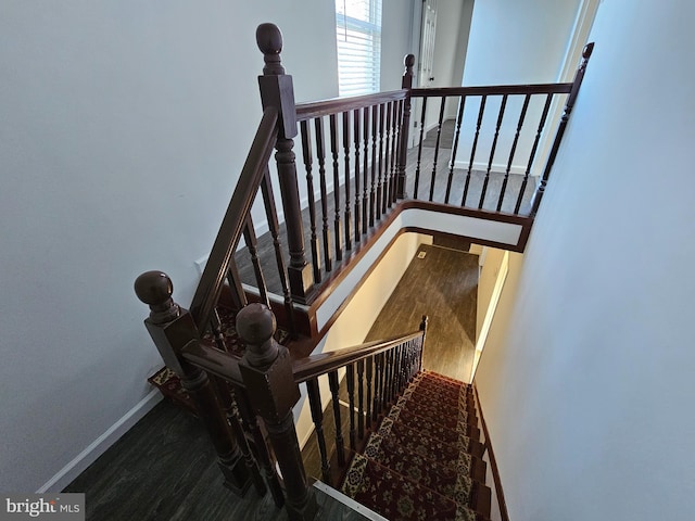 stairs featuring wood finished floors and baseboards