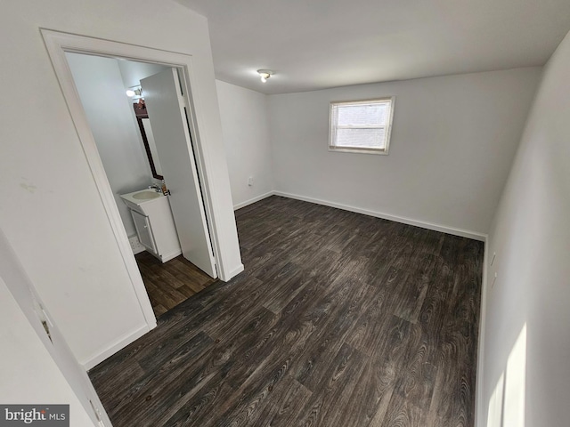 unfurnished room featuring dark wood-style floors and baseboards