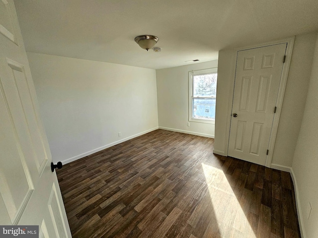 unfurnished bedroom featuring dark wood-style floors and baseboards