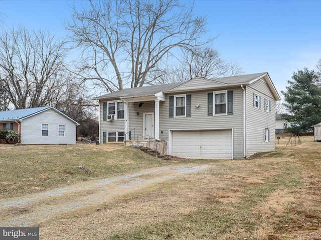 raised ranch featuring a front yard, driveway, and an attached garage