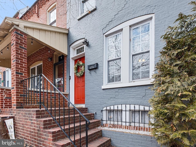 view of exterior entry with brick siding