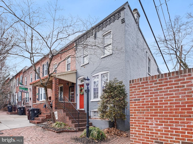 multi unit property with brick siding and a chimney