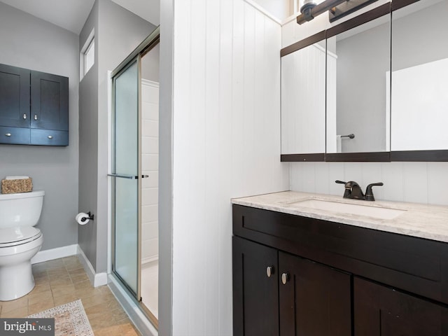 full bath featuring toilet, vanity, baseboards, tile patterned floors, and a stall shower