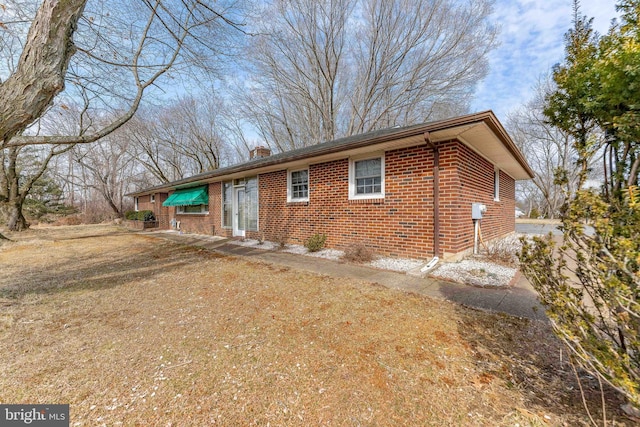 view of front of property featuring brick siding and a chimney