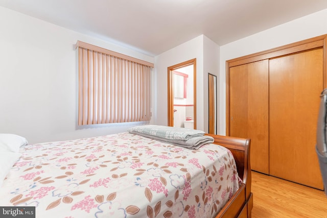 bedroom with light wood finished floors and a closet