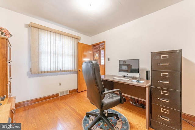 office area featuring visible vents, baseboards, and wood finished floors