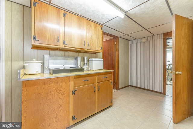 kitchen with brown cabinetry, light countertops, and baseboards