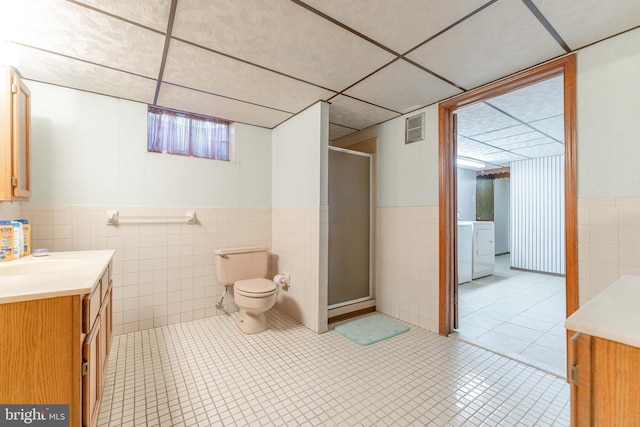 bathroom with washer / dryer, visible vents, toilet, vanity, and a shower stall