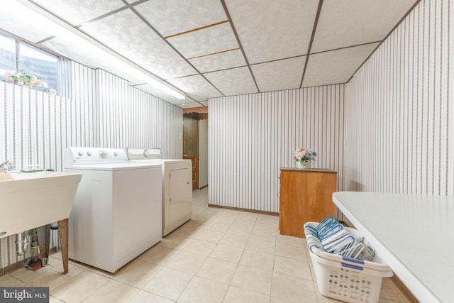 laundry area featuring laundry area, separate washer and dryer, light tile patterned flooring, and wallpapered walls