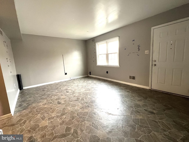 interior space featuring stone floors, visible vents, and baseboards