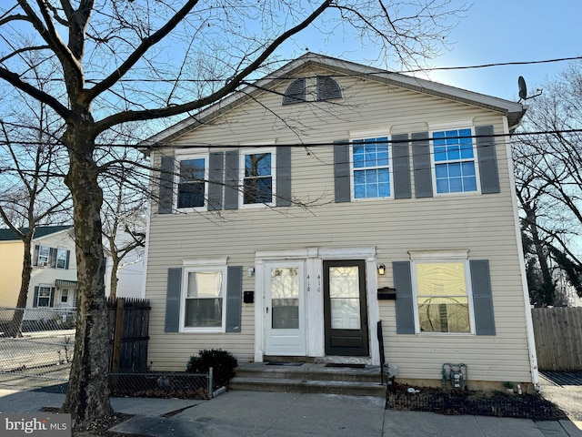 view of front of property with entry steps and fence