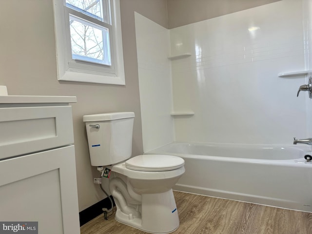 full bathroom with washtub / shower combination, vanity, toilet, and wood finished floors