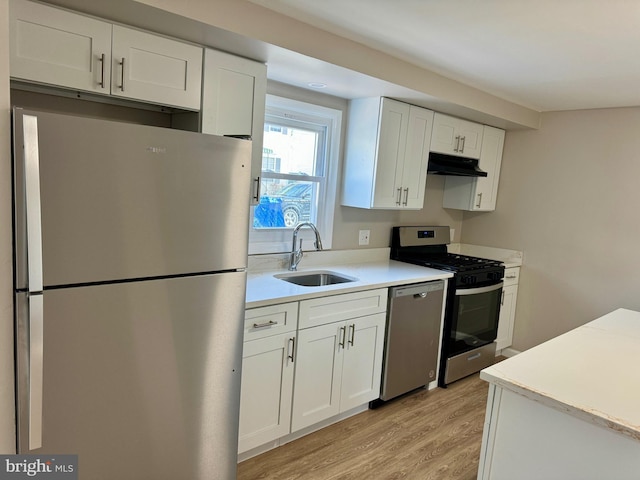 kitchen featuring a sink, white cabinetry, stainless steel appliances, and light countertops