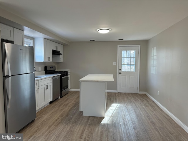 kitchen featuring light countertops, appliances with stainless steel finishes, a center island, and white cabinets