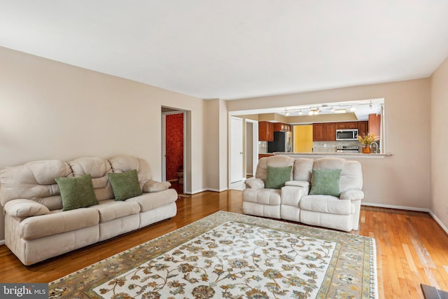 living room with light wood finished floors and baseboards