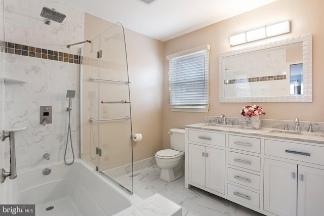 full bathroom featuring double vanity, marble finish floor, toilet, and a sink