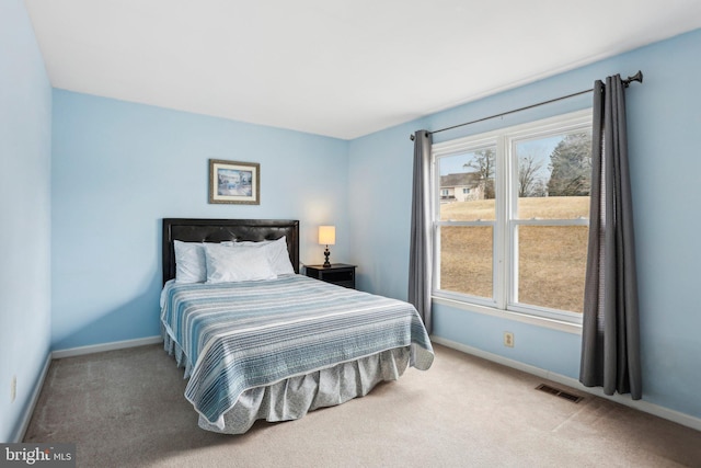 carpeted bedroom featuring visible vents and baseboards