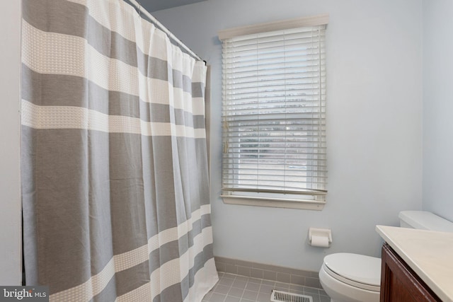 bathroom featuring visible vents, toilet, vanity, baseboards, and tile patterned floors