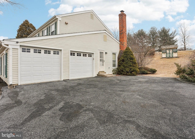 view of side of property featuring aphalt driveway and a garage