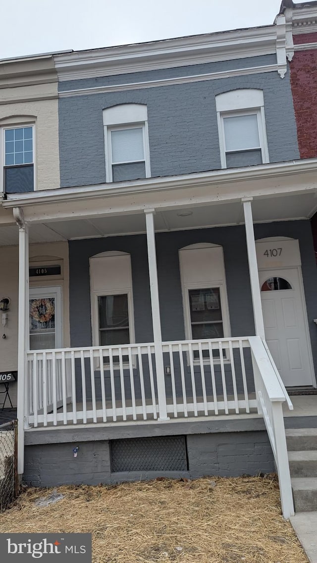 exterior space with covered porch and brick siding