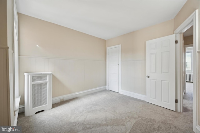 unfurnished bedroom with carpet floors and wainscoting