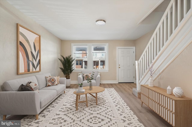 living room with stairway, baseboards, and wood finished floors