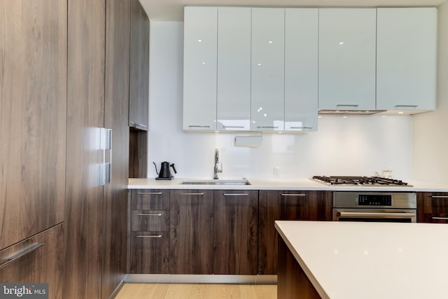 kitchen with modern cabinets, white cabinetry, appliances with stainless steel finishes, and a sink