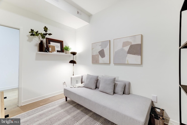 living area featuring visible vents, baseboards, and wood finished floors