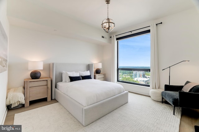 bedroom with a notable chandelier and wood finished floors