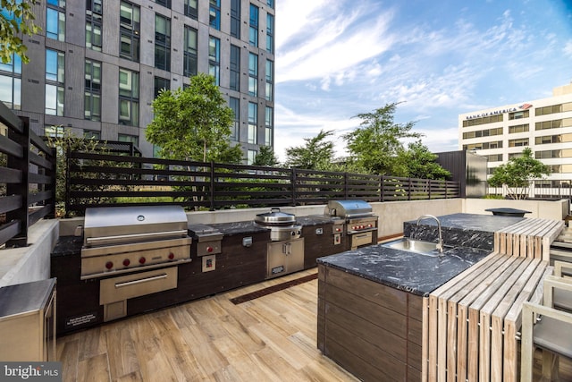 wooden deck with a sink, area for grilling, and a grill