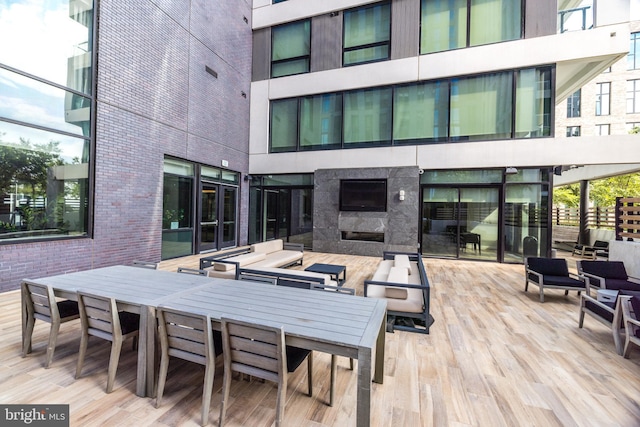 wooden deck featuring outdoor dining space and exterior fireplace