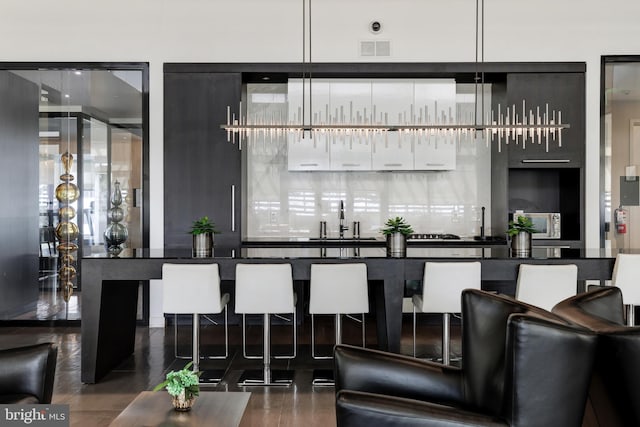 bar featuring a sink, visible vents, and pendant lighting