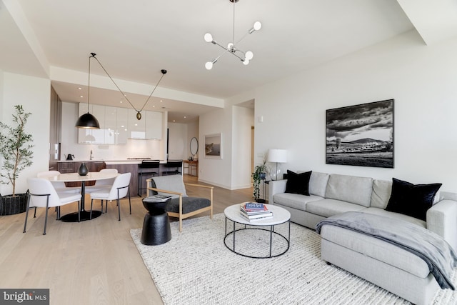 living room with light wood-style floors, recessed lighting, and a notable chandelier