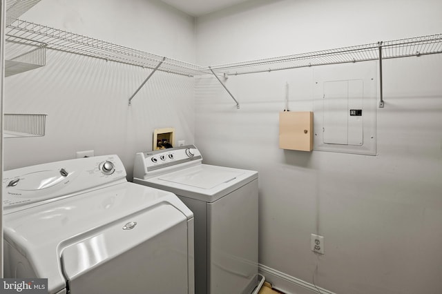 laundry room with laundry area, electric panel, and washing machine and clothes dryer