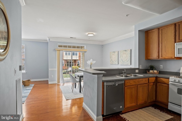 kitchen featuring dark countertops, white appliances, brown cabinetry, and a sink