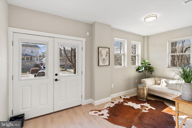 entrance foyer featuring french doors, light wood finished floors, visible vents, and baseboards