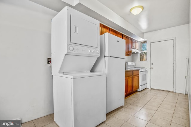 laundry area featuring stacked washing maching and dryer, light tile patterned floors, and laundry area