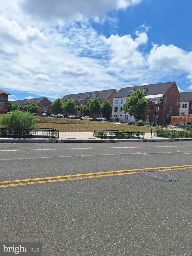 view of street with curbs, sidewalks, and a residential view