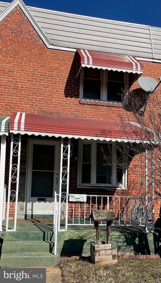 view of front of property with a porch and brick siding