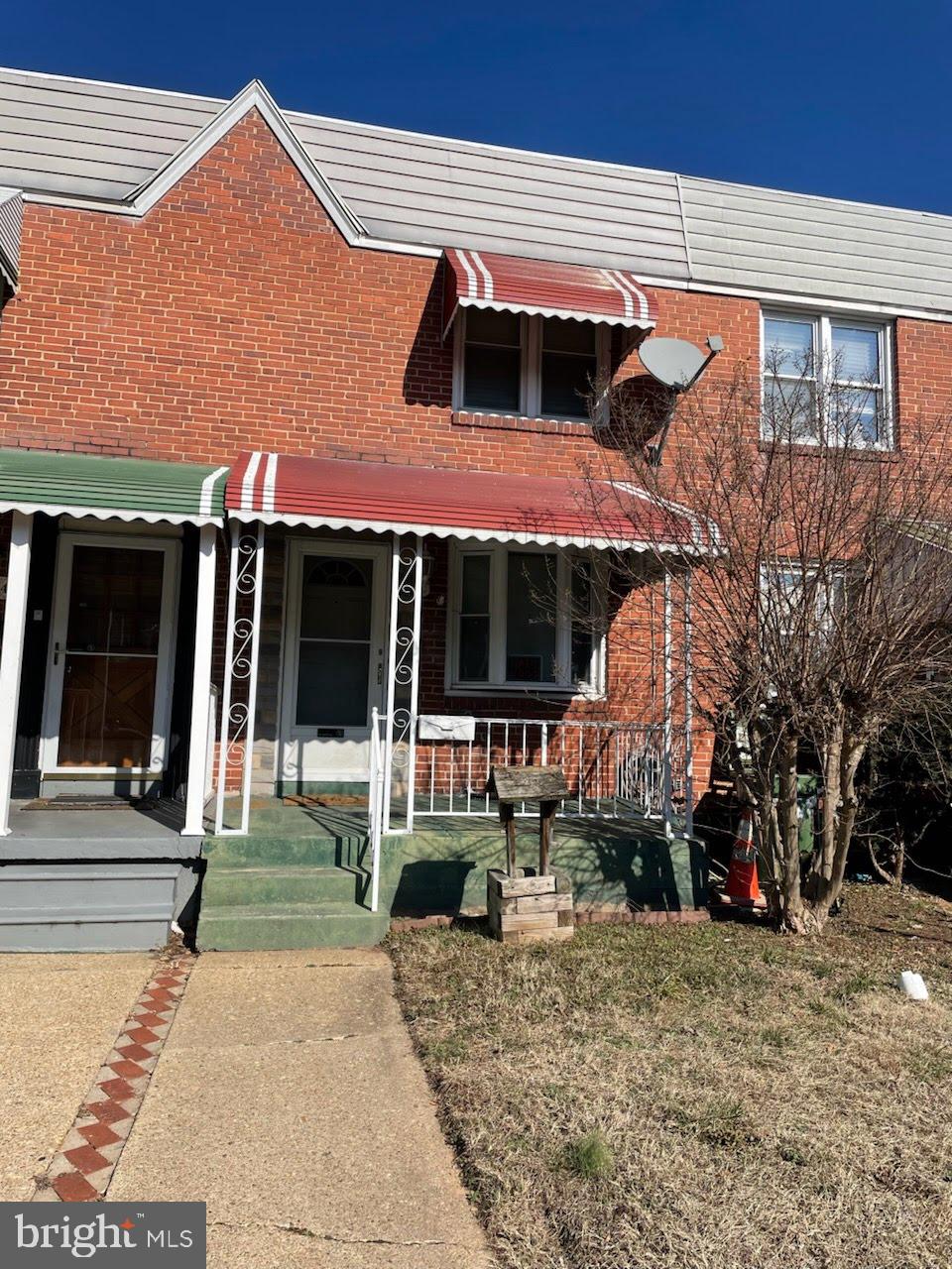 view of front of home featuring brick siding and a porch