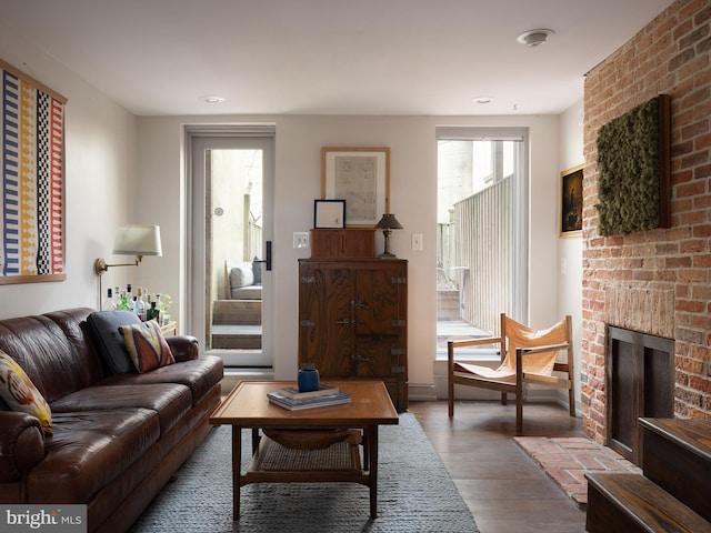 living area featuring a brick fireplace and wood finished floors